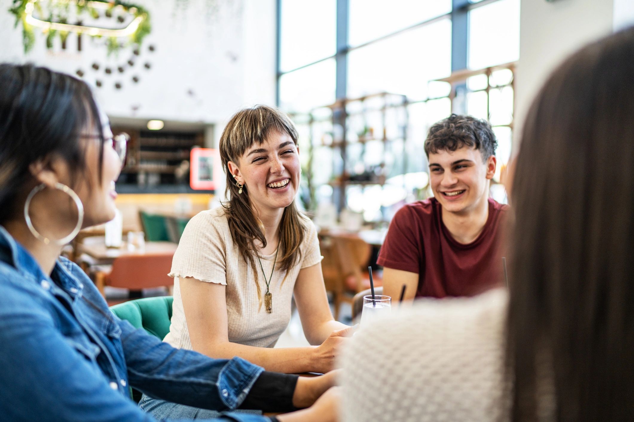 Friends laughing together at a cafe table