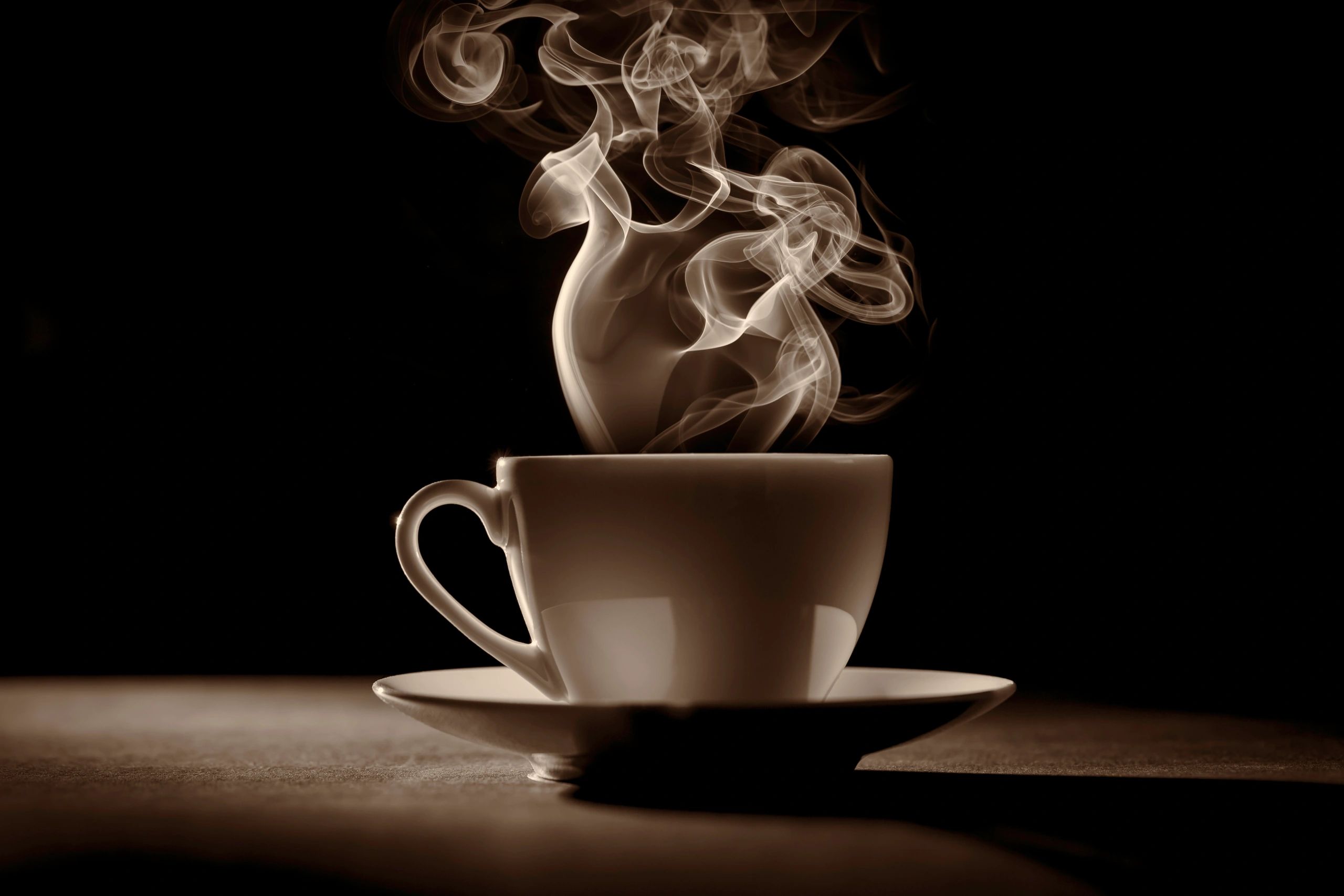 Cup of coffee with steam on a dark background